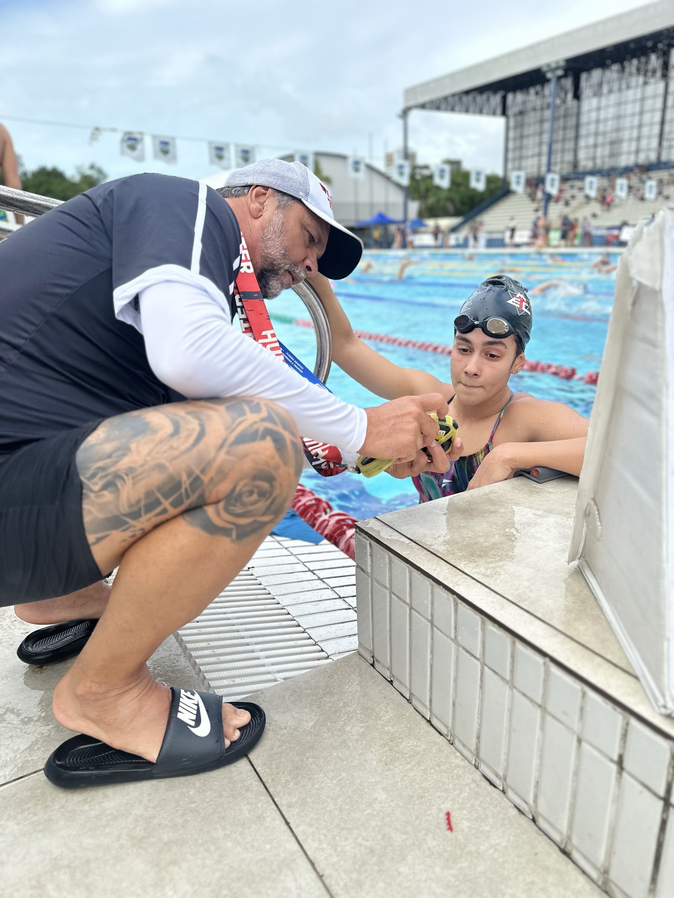 Marão agachado na borda orientando um jovem atleta
